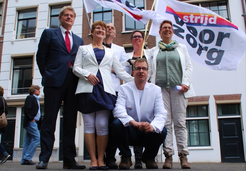 Staatssecretaris van Volksgezondheid, Welzijn en Sport, Martin van Rijn (links) naast enkele FNV actievoerders.